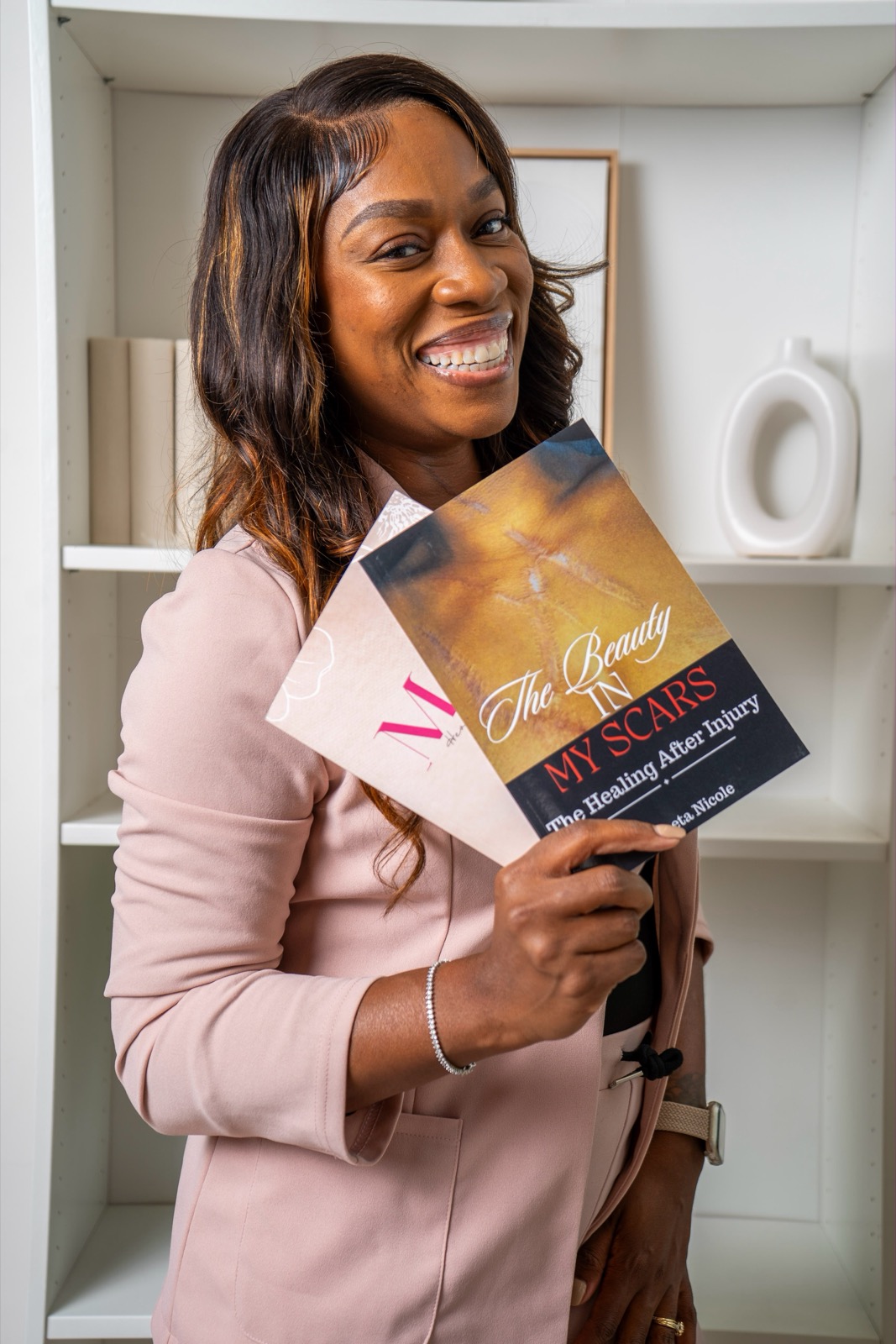 Shreeta Nicole holding her book The Beauty in My Scars